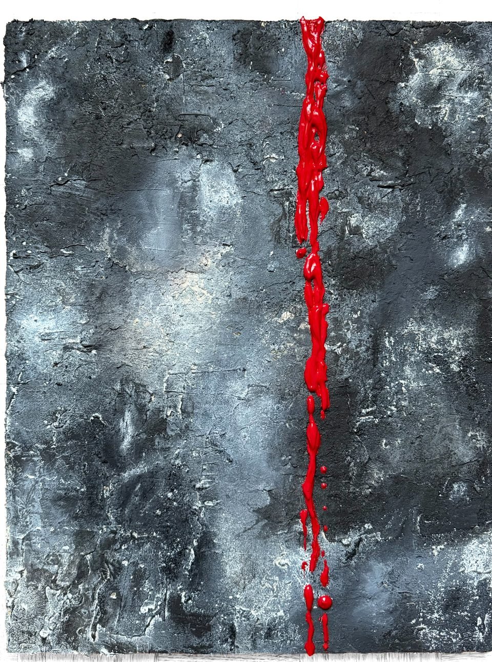 Fêlure — panneau de béton gris et noir, fendu verticalement par une coulée de peinture rouge vif.